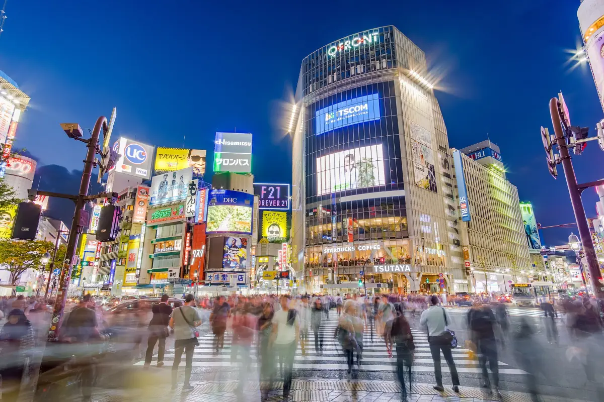 Shibuya Crossing at dusk with crowds and screens